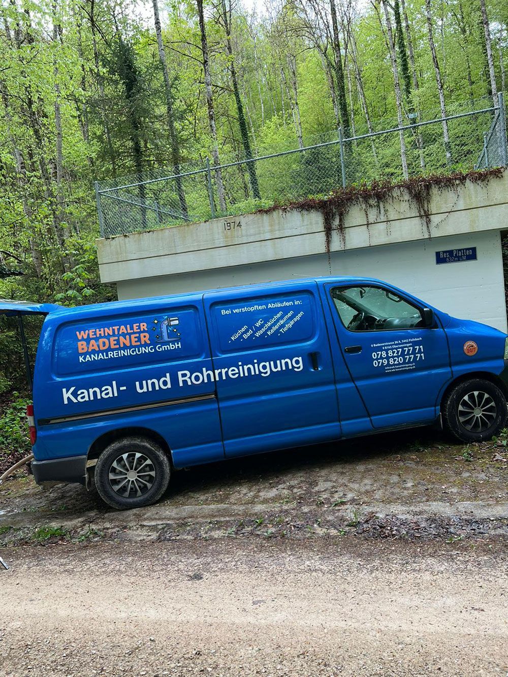 Vor einem Gebäude parkt ein blauer Lieferwagen.