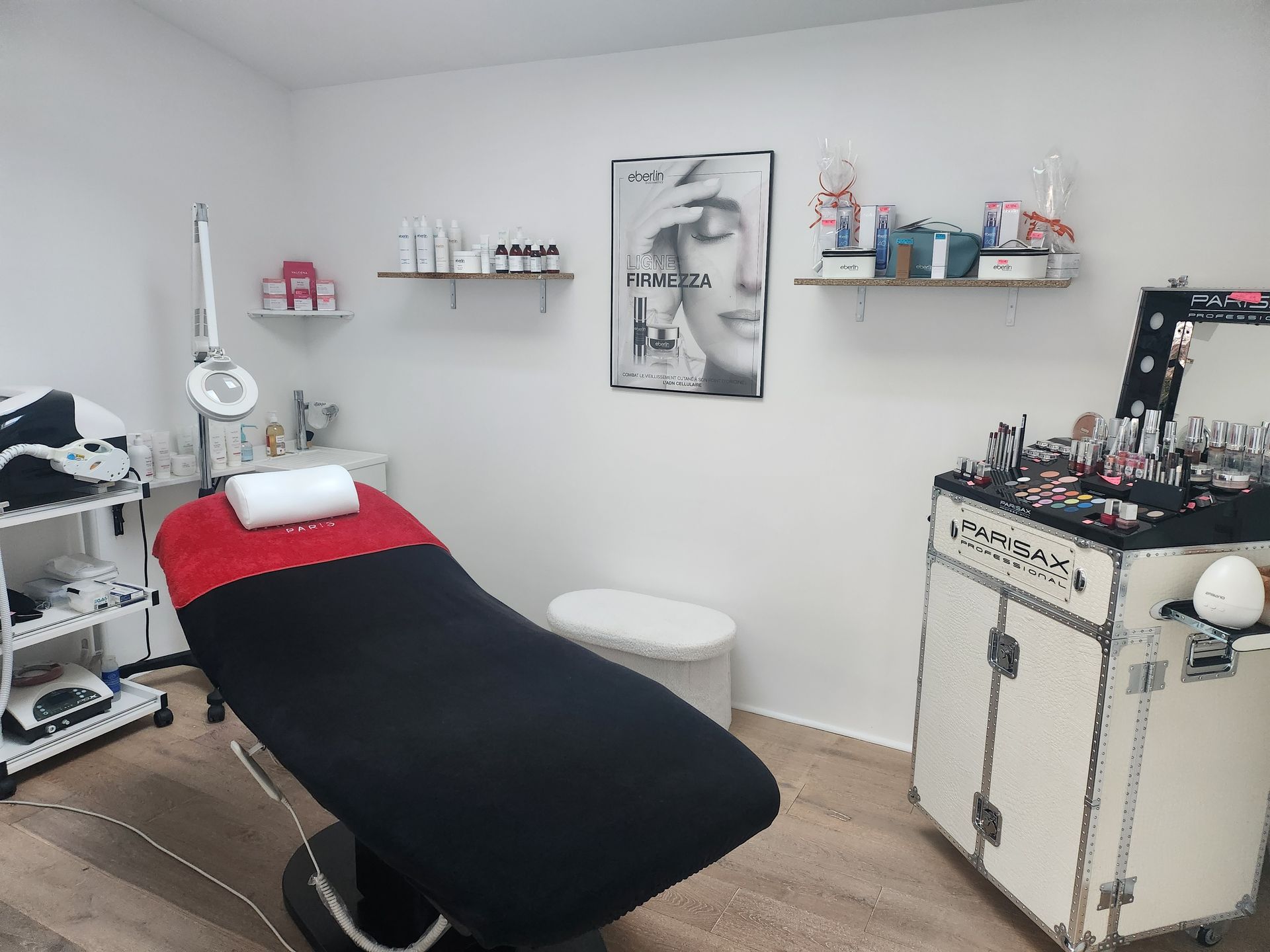 Salle de soins esthétiques avec un fauteuil noir et rouge