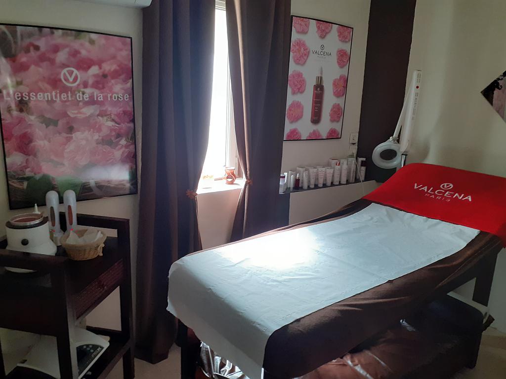 Table de massage dans une chambre avec des cadres roses.