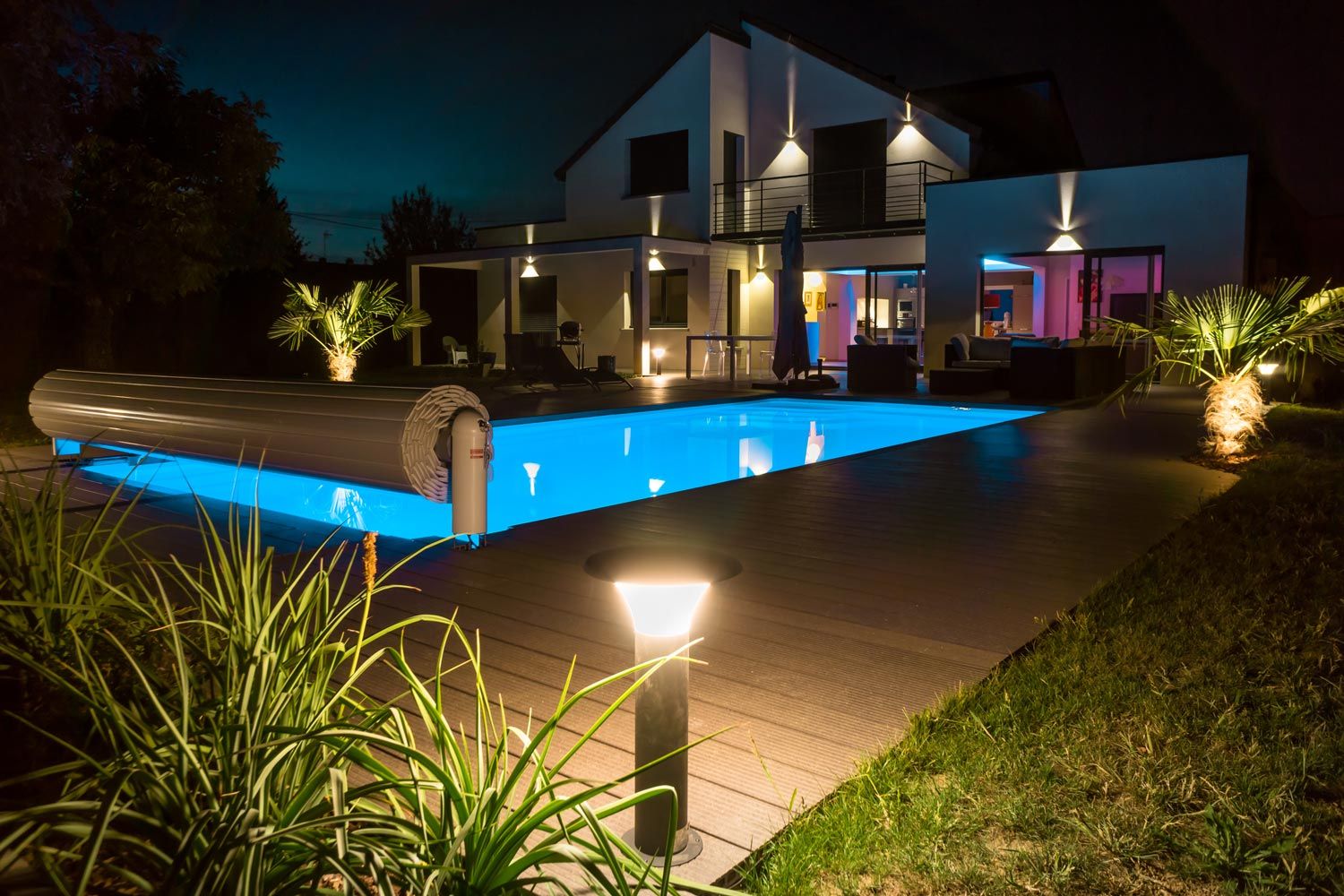 Éclairage nocturne d'une maison avec sa terrasse et sa piscine