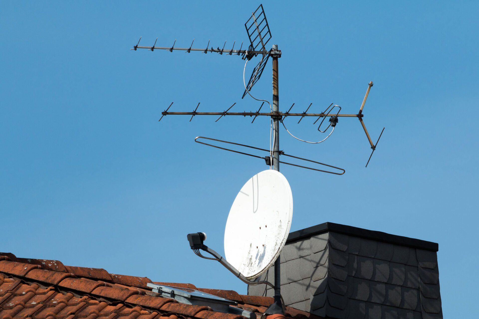 Parabole et antenne TV sur le toit d'une maison