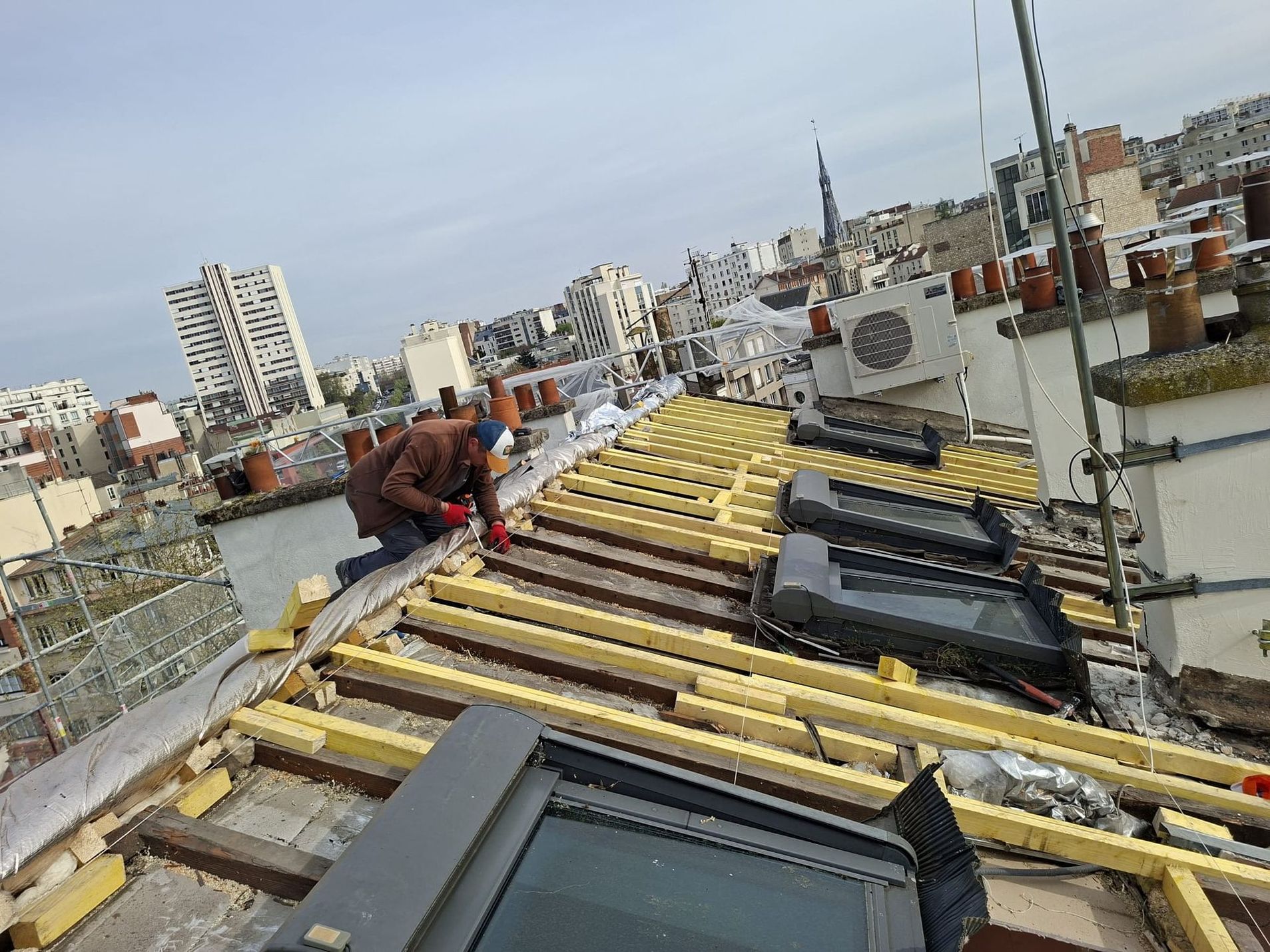 Des ouvriers installent une charpente.