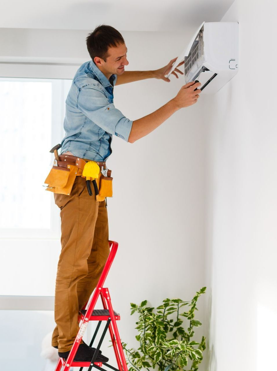 Un technicien sur un escabeau qui travaille
