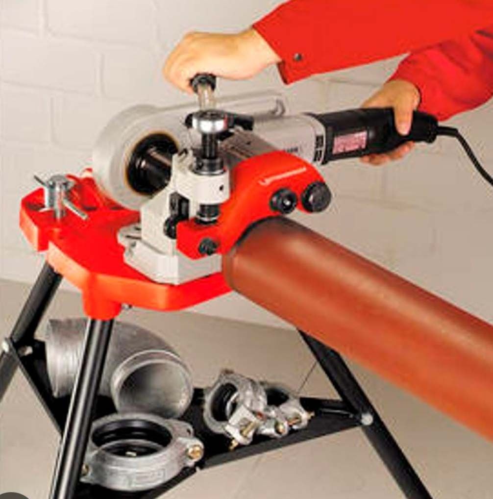 Una persona está usando una máquina para cortar un tubo.