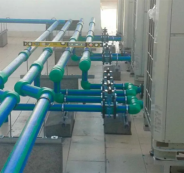 Una fila de tuberías azules y verdes están conectadas a un edificio.