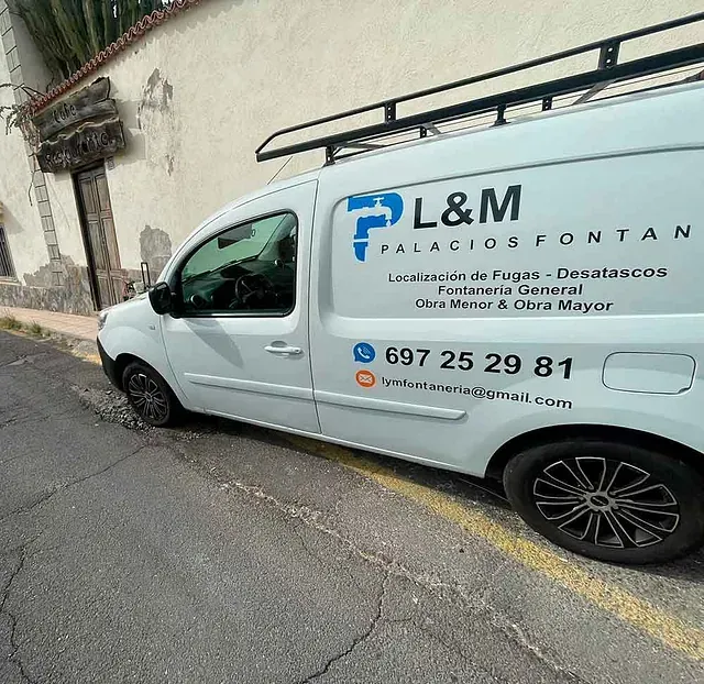 Una camioneta blanca está estacionada al costado de la carretera.