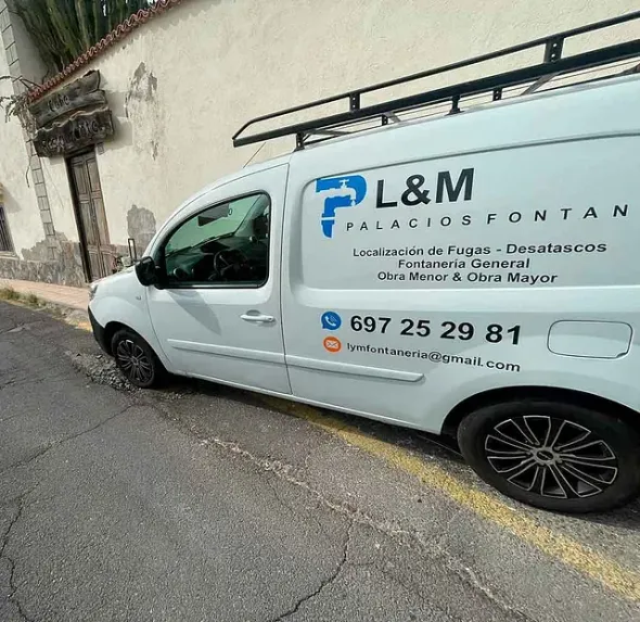 Una camioneta blanca está estacionada al costado de la carretera.