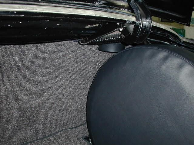 Auf dem Rücksitz eines Autos liegt eine schwarze Reifenabdeckung.