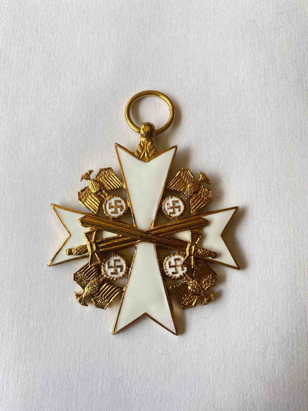 Medalla de oro y blanco con joyas, con motivos de cruz y esvástica sobre fondo liso.