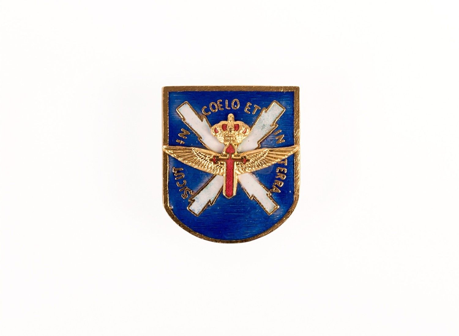 Emblema de escudo azul con alas blancas cruzadas, espada dorada y estrella roja