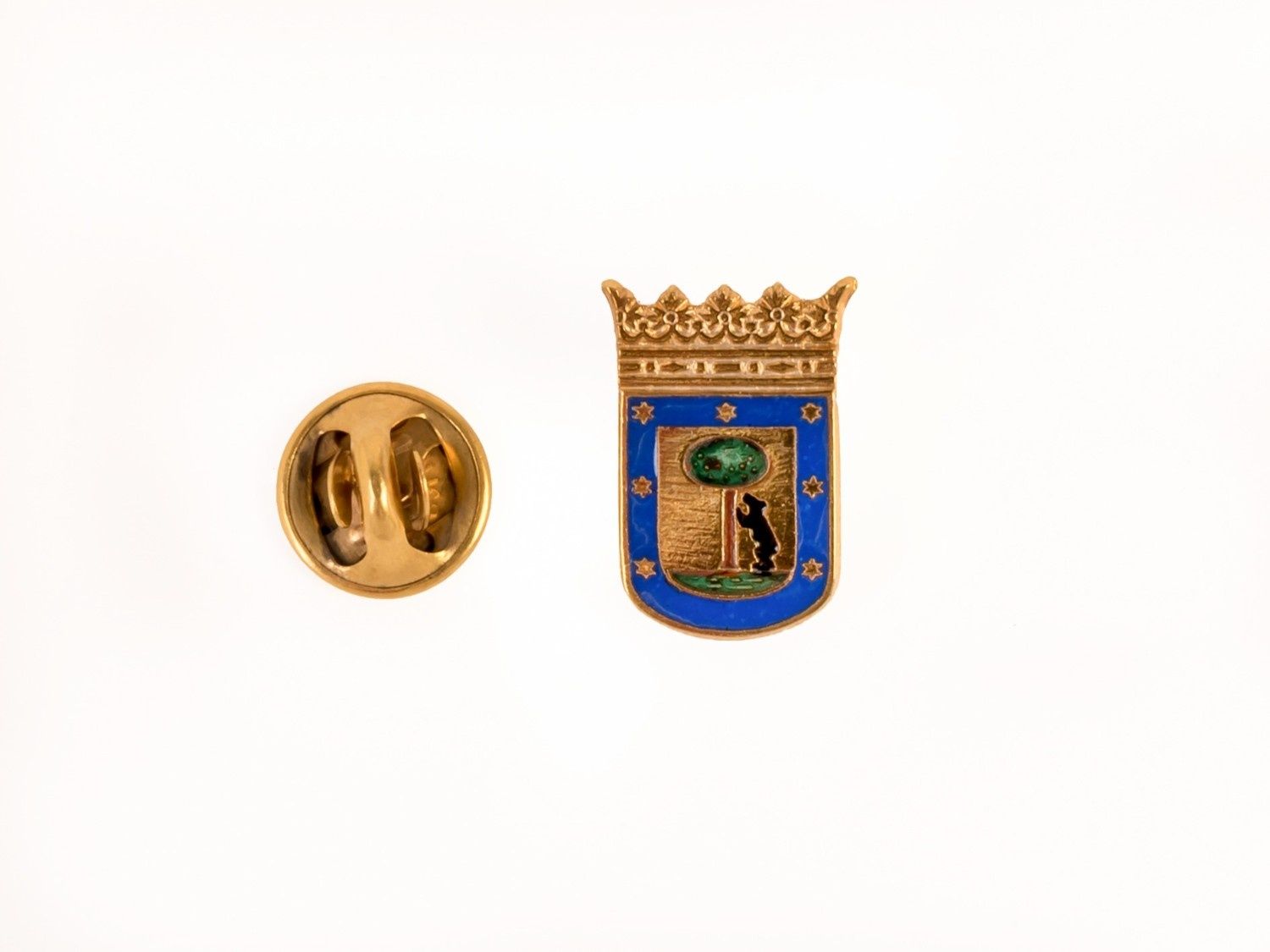 Dos pequeños pines de solapa esmaltados, uno dorado y otro azul con un emblema de corona.