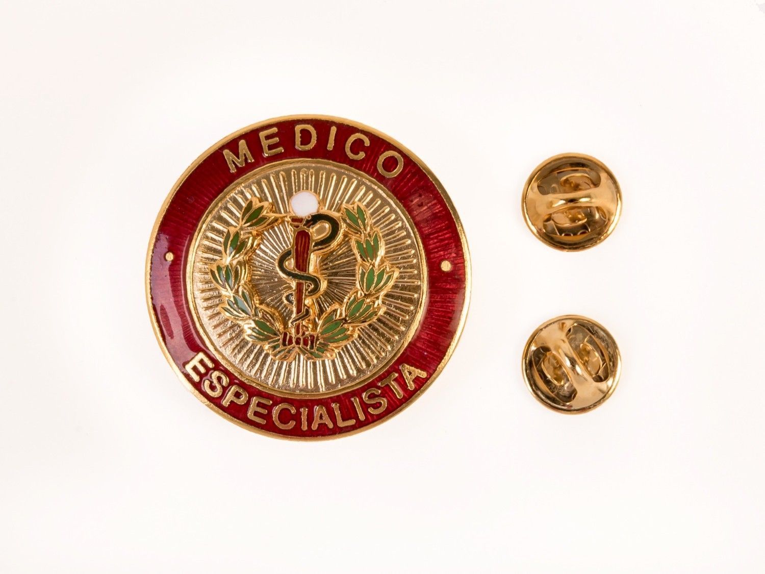 Pin de Médico Especialista rojo y dorado con dos pequeños pines dorados sobre fondo blanco.