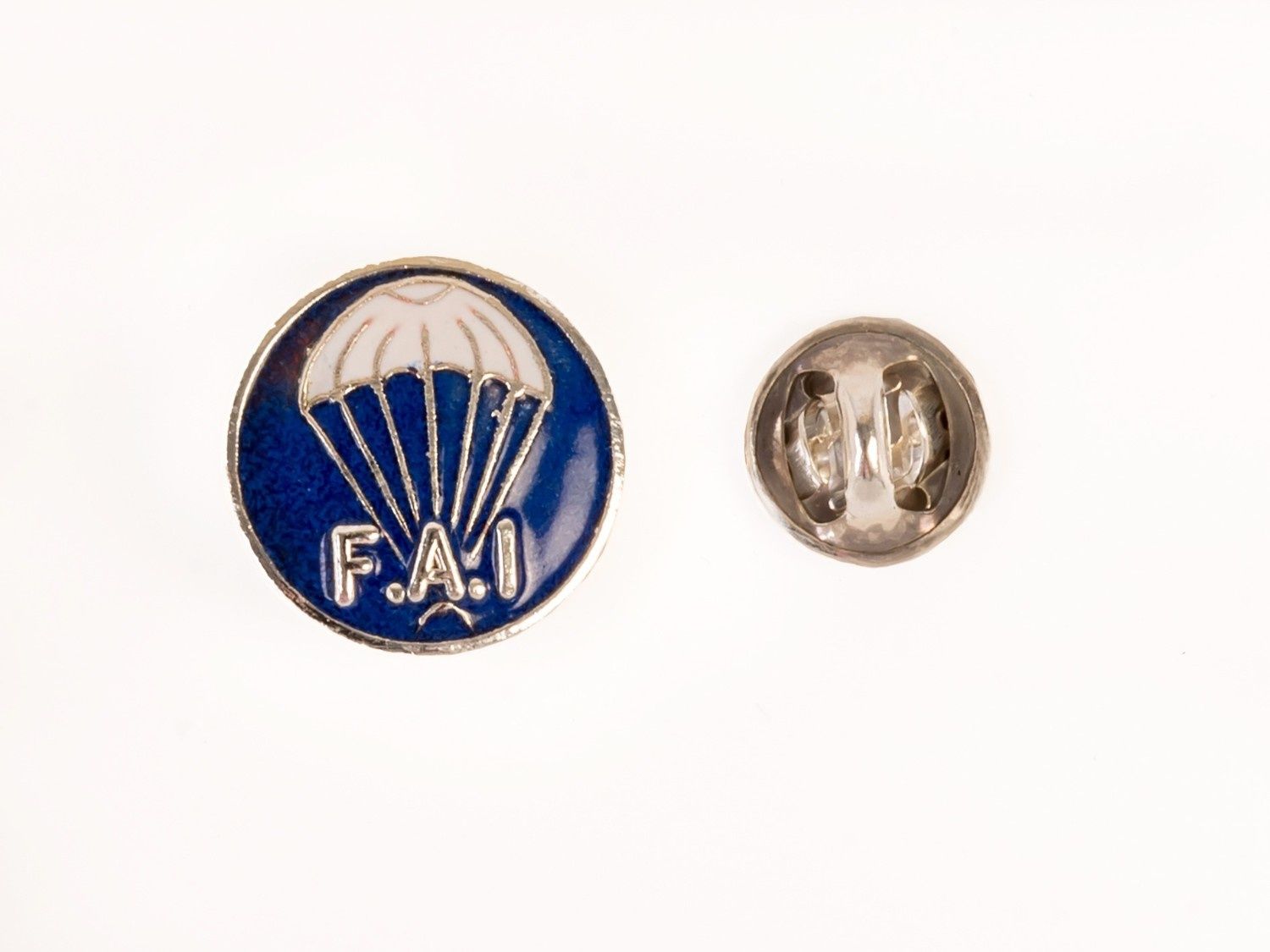 Pin de solapa de la FAO en azul y dorado con diseño de paracaídas, mostrado con su cierre metálico trasero.