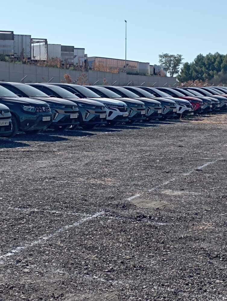 Un parque de casas rodantes polvoriento con autocaravanas estacionadas bajo un cielo azul claro.