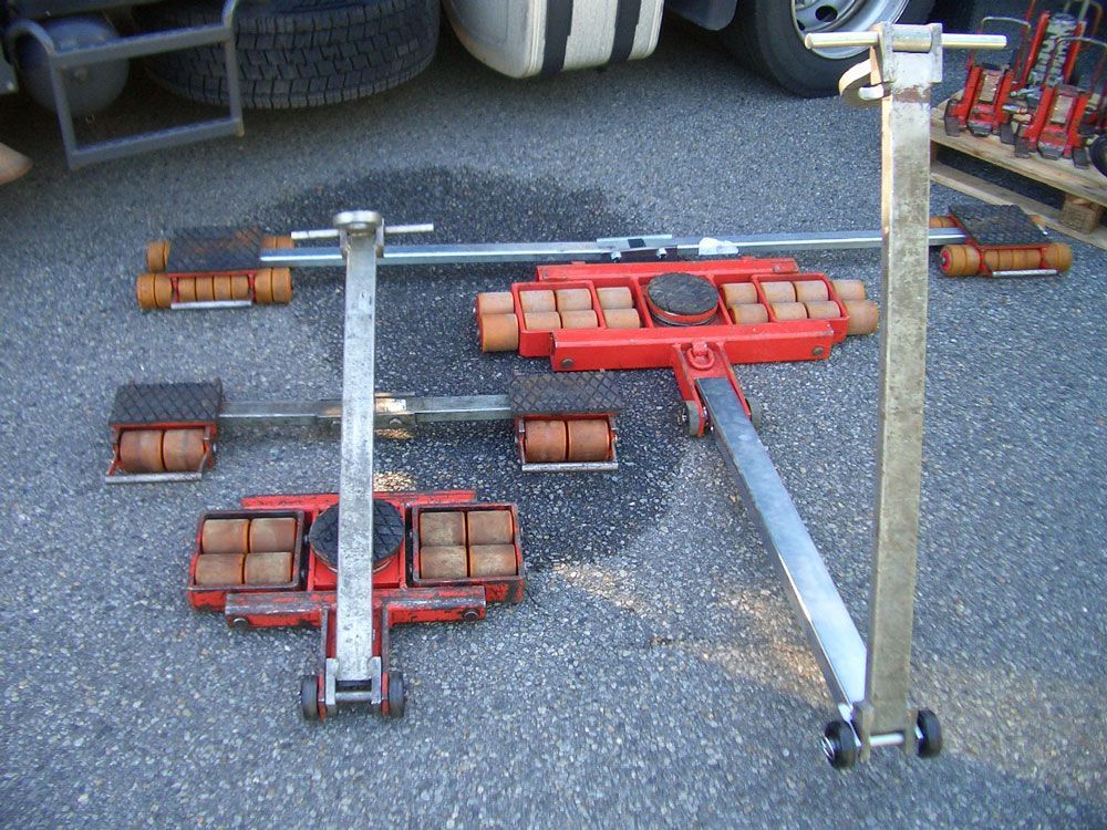 LKW-Radrollen auf Asphalt. Rote und orangefarbene Rollen auf Metallrahmen.