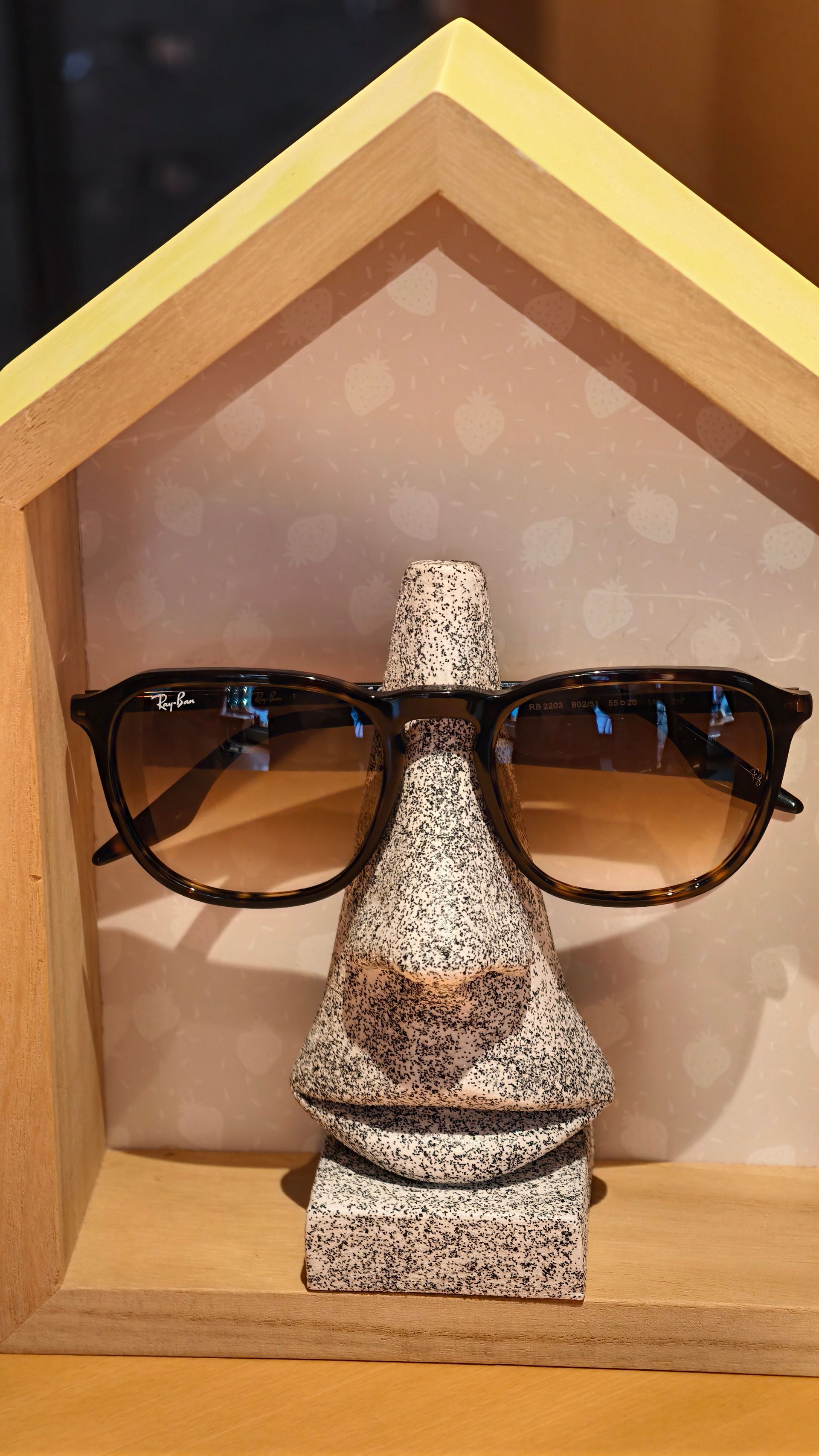 Eine Frau mit Strohhut und Sonnenbrille lächelt.