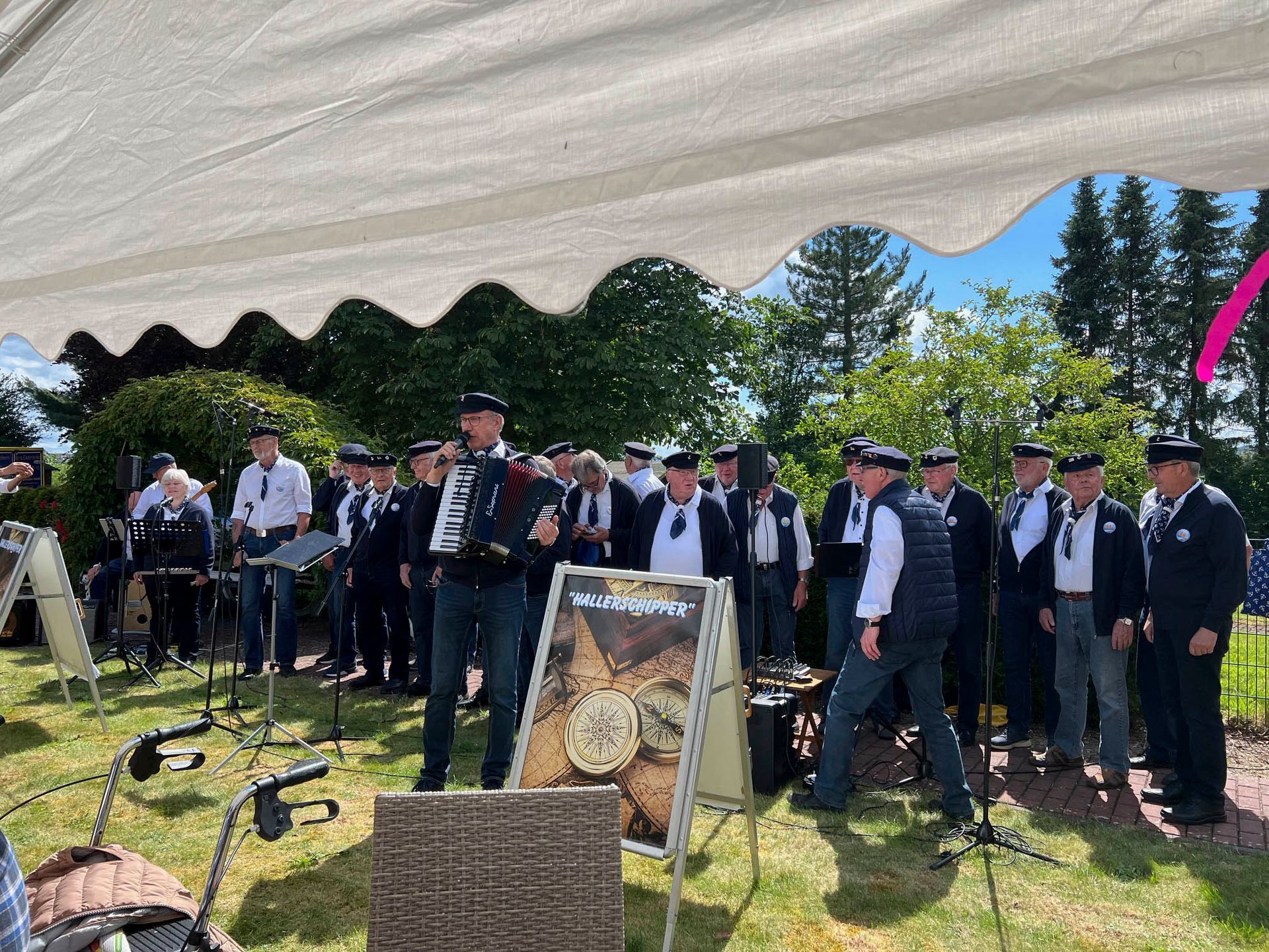 Eine Gruppe Männer steht unter einem Zelt und spielt Instrumente.