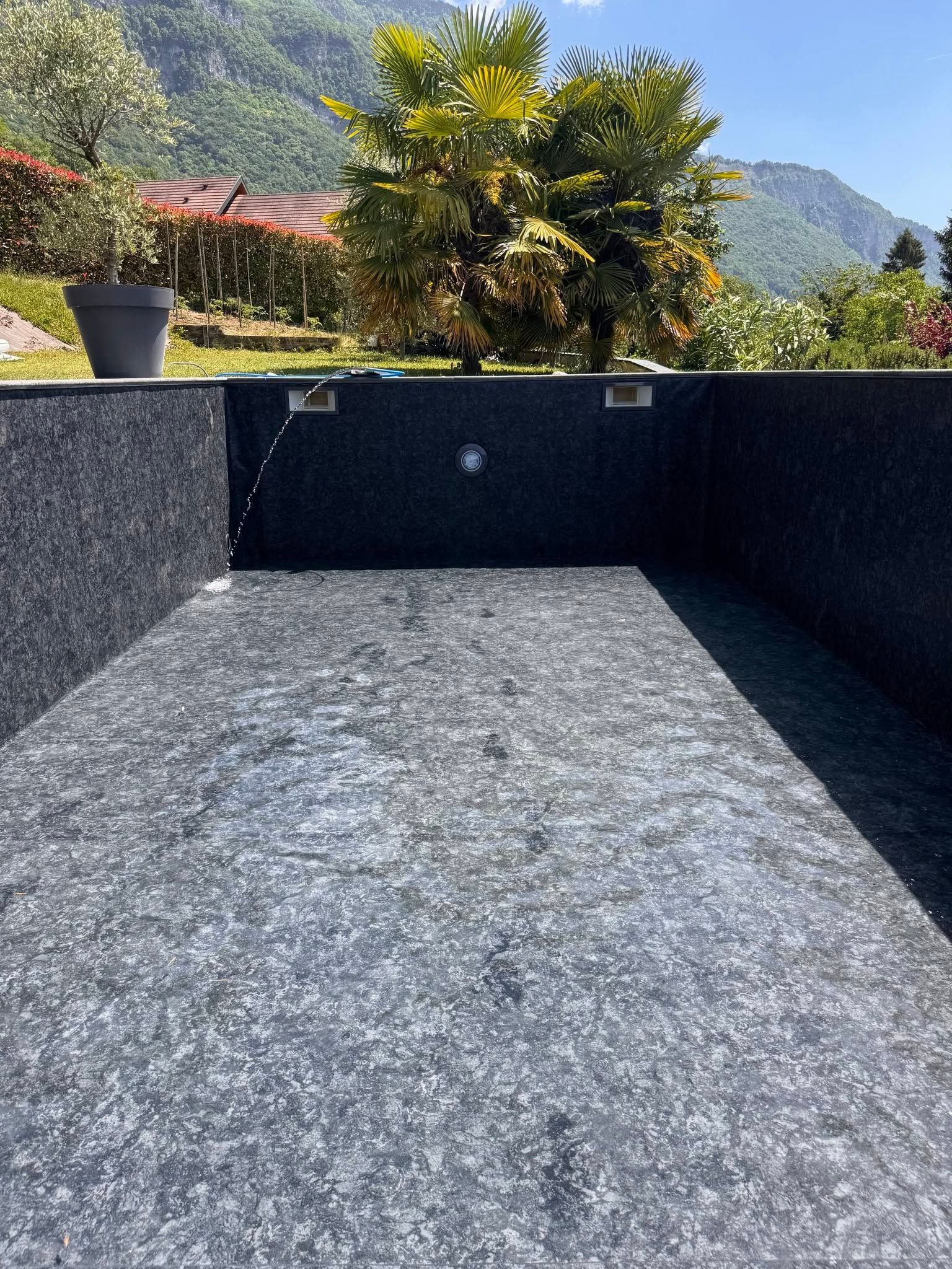 Piscine avec murs en pierre sombre.