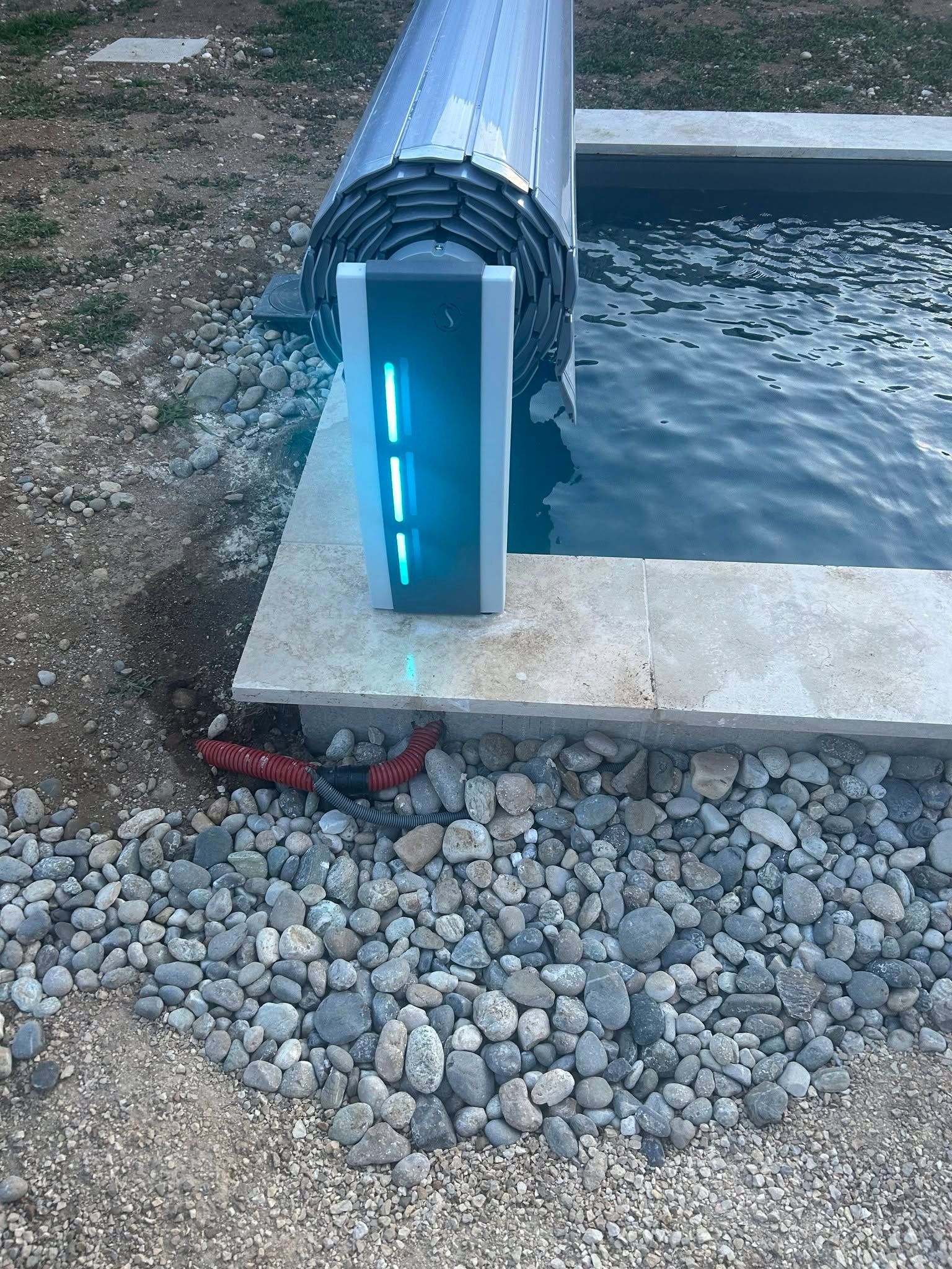 Dispositif lumineux bleu installé sur le bord d'une piscine en béton.