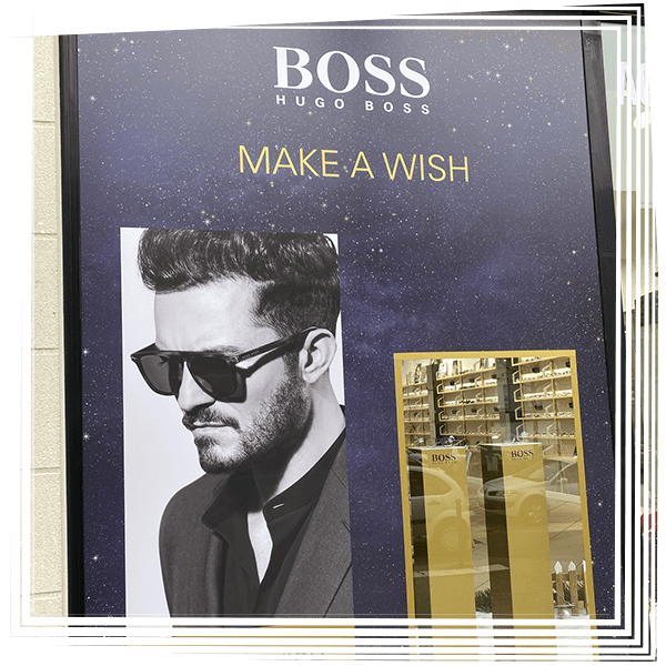 Publicité Hugo Boss Faites un vœu avec un homme en noir et blanc portant des lunettes de soleil sur fond bleu marine