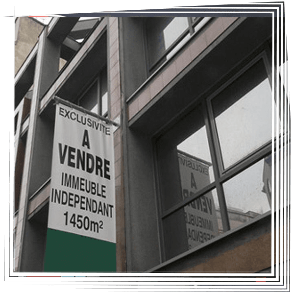 Panneau À vendre sur la façade d'un immeuble, annonçant une propriété indépendante de 1 450 m²