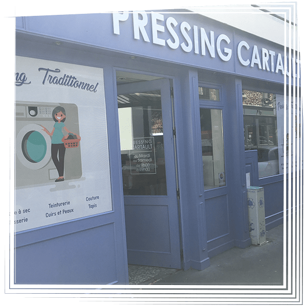 Façade bleue avec une enseigne PRESSING et une affiche sur le mur de gauche.