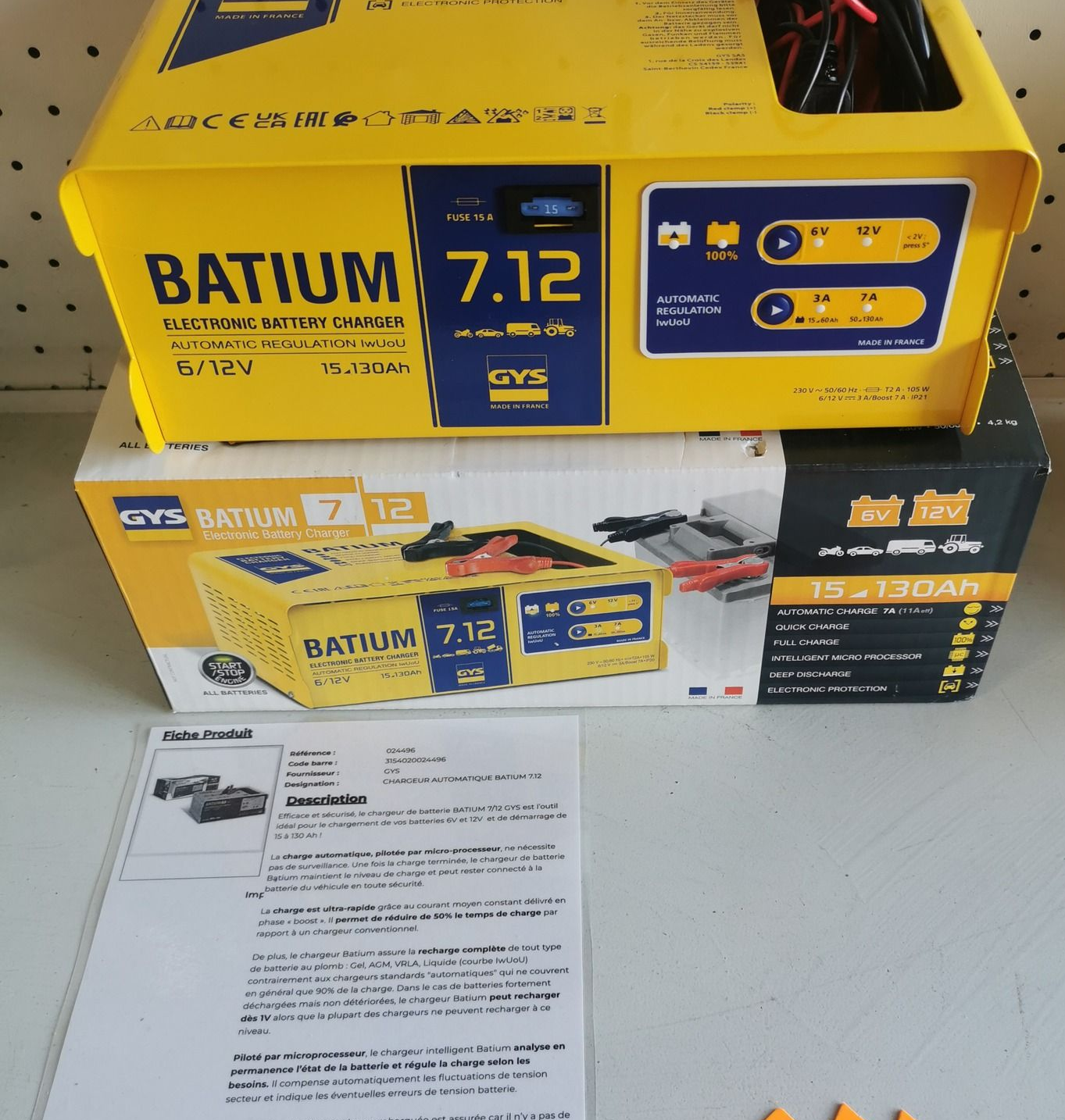 Deux chargeurs de batterie jaunes empilés, l'un étiqueté BATIUIM 7.12, notice d'instructions en dessous.