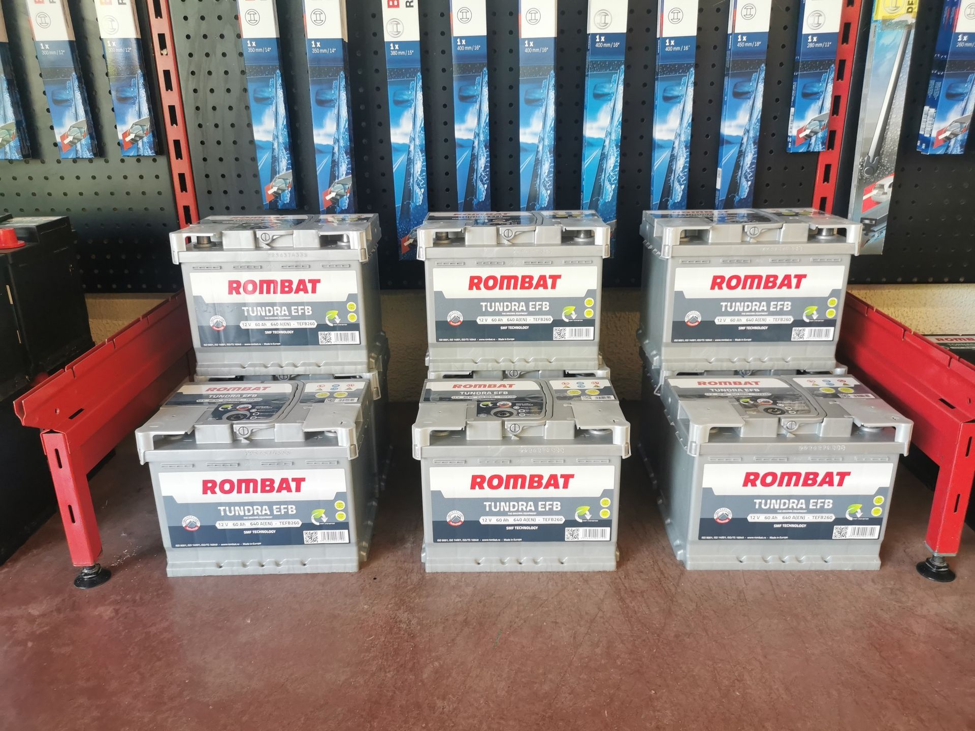 Six batteries de voiture empilées ; de marque Rombat, dans un magasin.