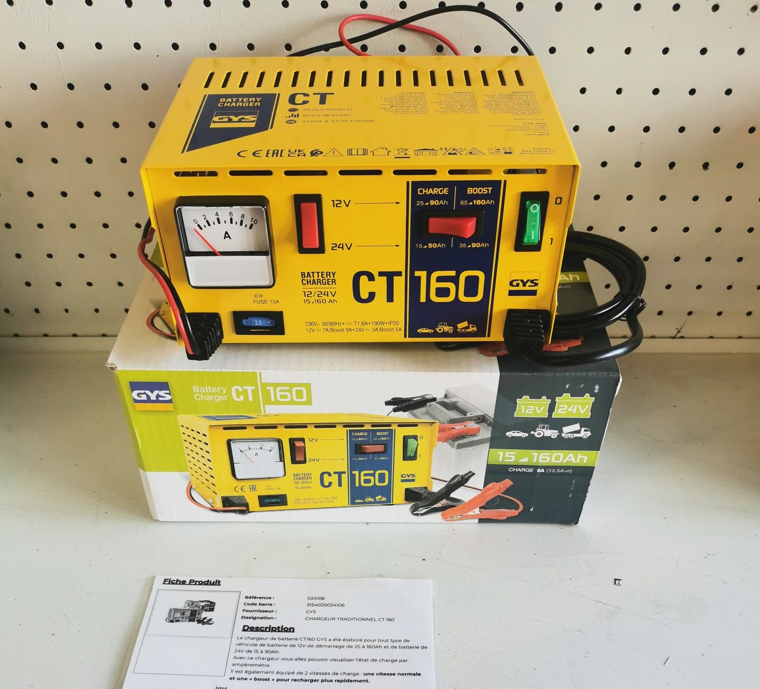 Chargeur de batterie CT 160 jaune sur sa boîte, avec un indicateur, des boutons et des câbles.