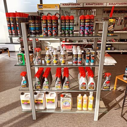 Étagère dans un magasin présentant divers produits d'entretien automobile, notamment des aérosols et des flacons.