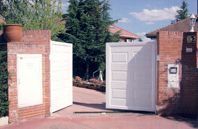 Una puerta blanca está abierta delante de una pared de ladrillos.