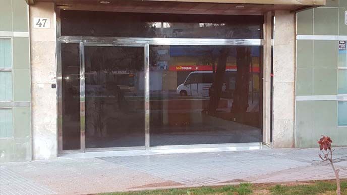 Un edificio con una puerta corrediza de vidrio y un marco de acero inoxidable.