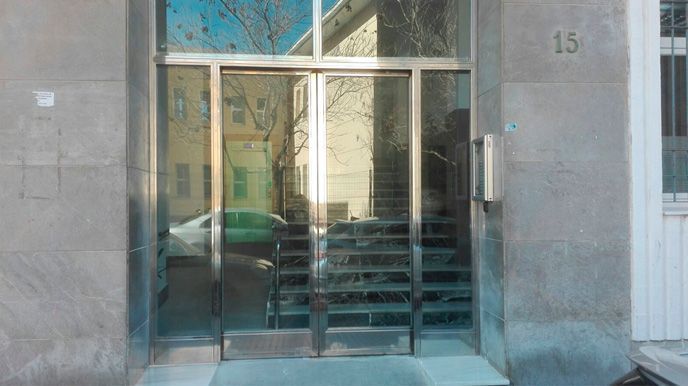 Un edificio con una puerta corrediza de vidrio y escaleras que conducen a él.