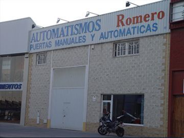 Una motocicleta está estacionada frente a un edificio que dice romero