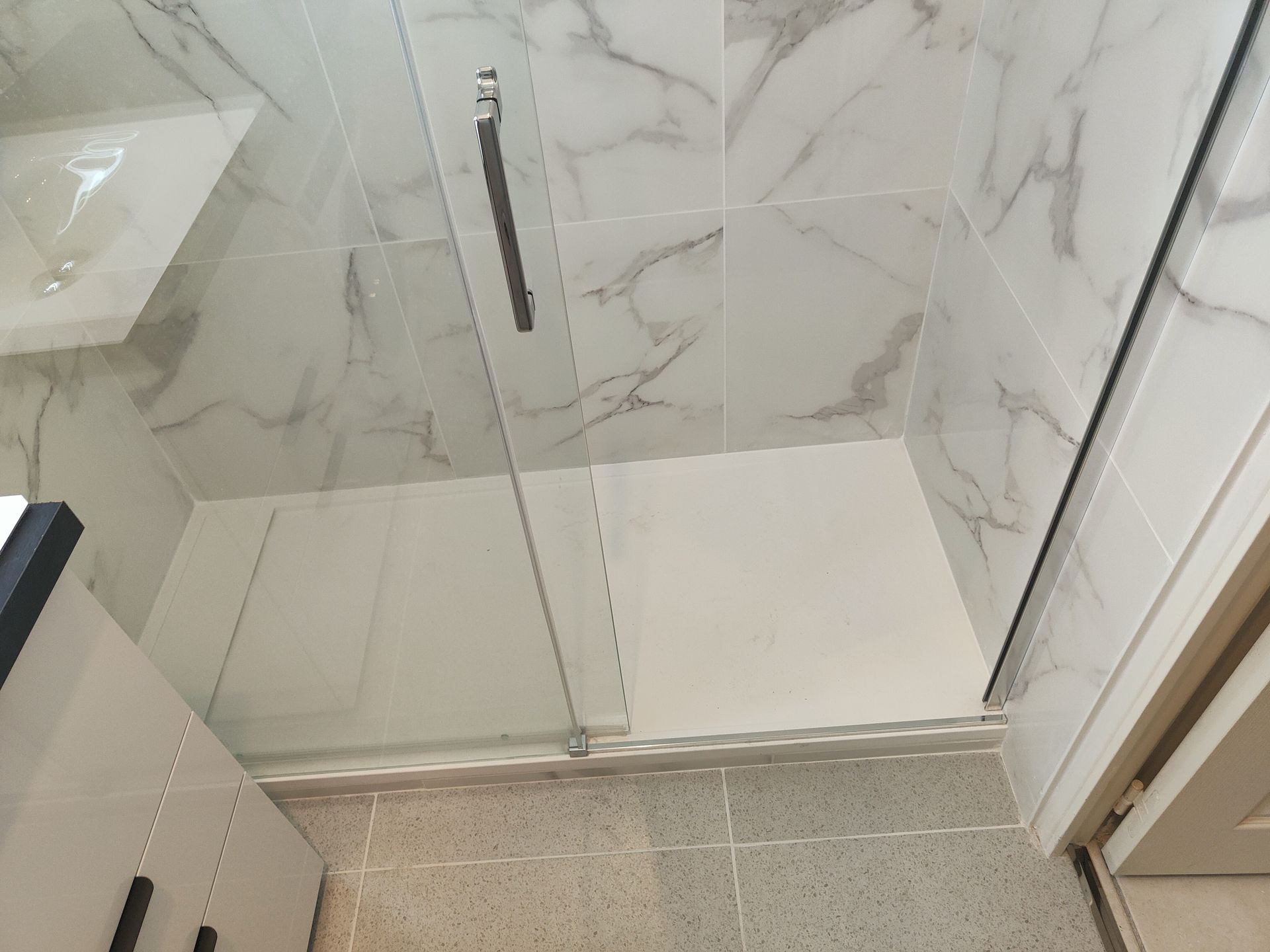 Sol carrelé en forme de tomettes en différentes teintes de gris