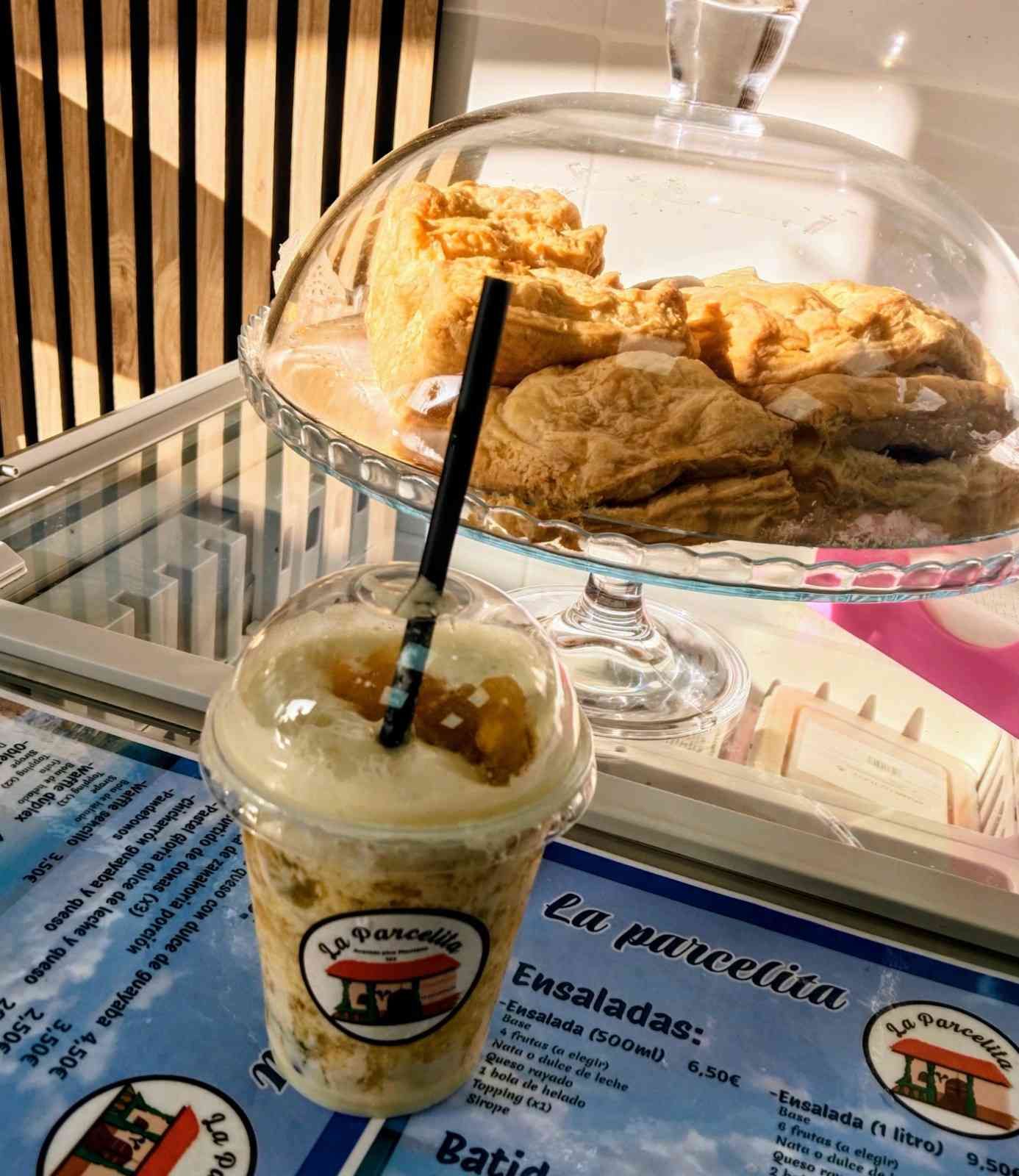 Un helado y un batido sobre el mostrador de una cafetería, con una bandeja con el menú al lado.