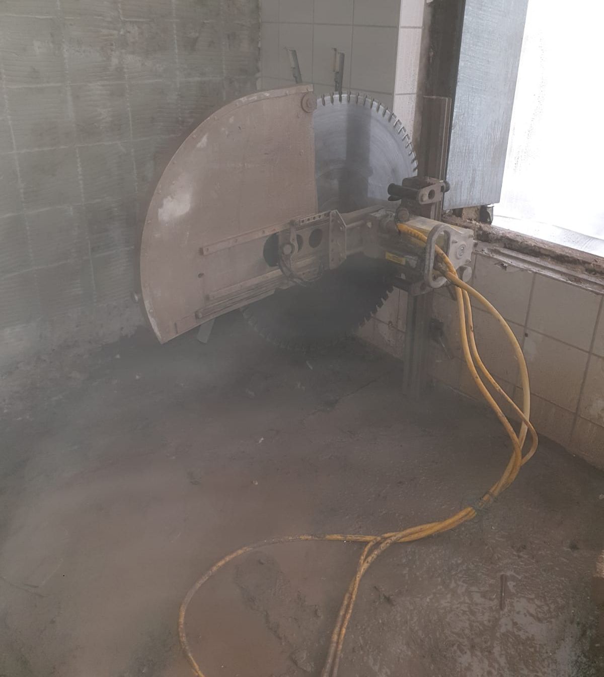 Das Loch für ein Fenster wird mit Hilfe einer Säge vergrößert