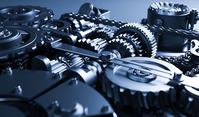 Nahaufnahme von ineinandergreifenden Metallzahnrädern in einer bläulich getönten mechanischen Konstruktion