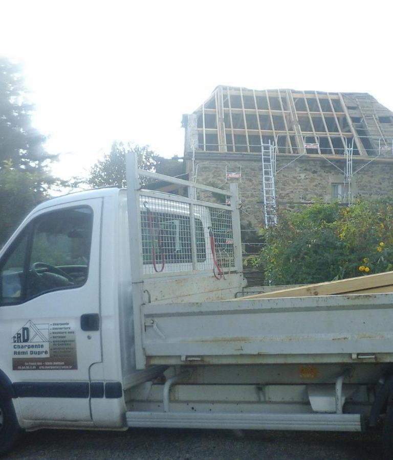 Charpente en cours de montage sur un chantier avec camion en premier plan