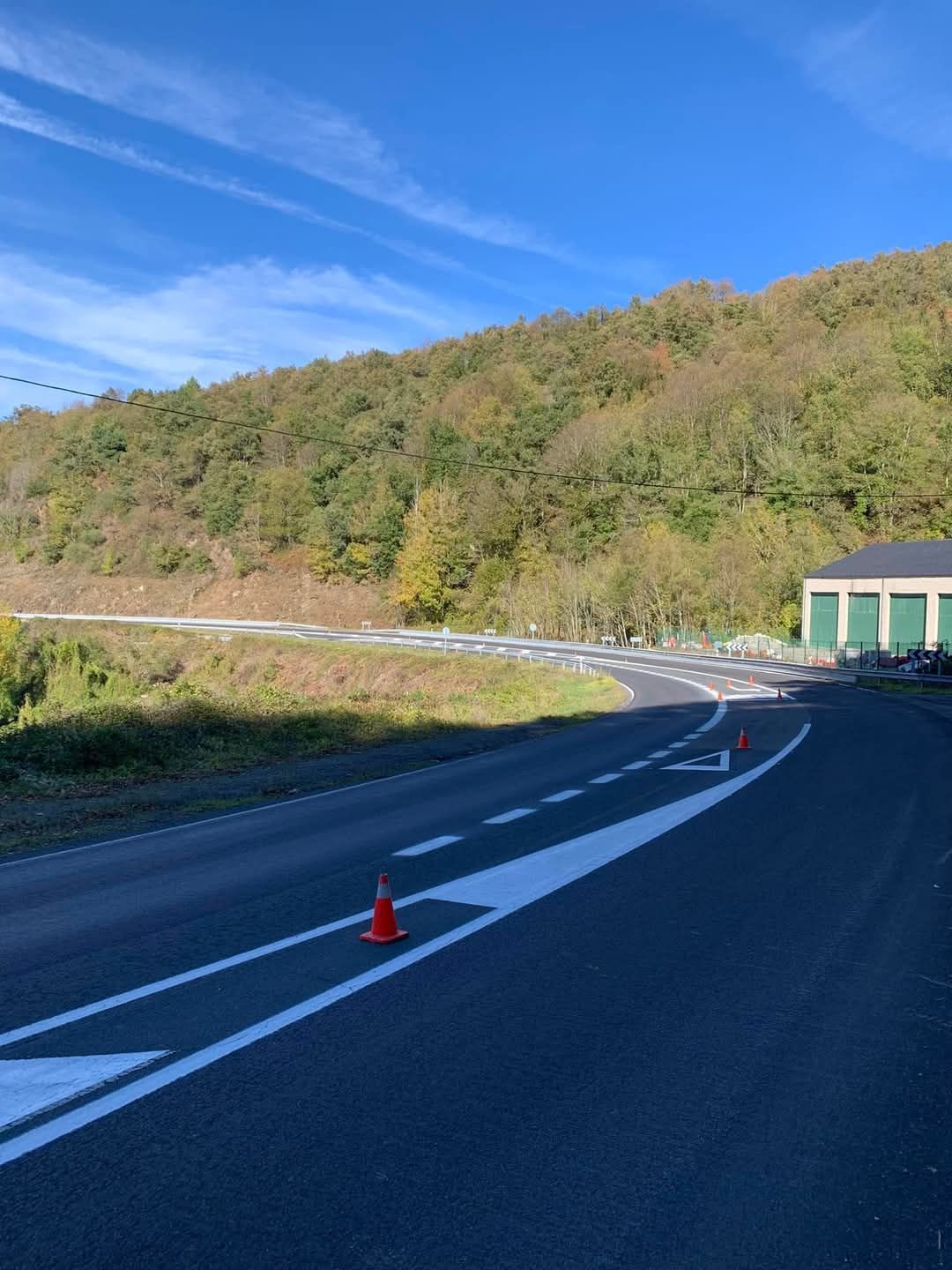 Una carretera con un cono al costado