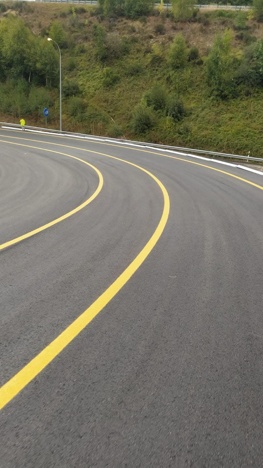 Una carretera con curvas con una línea amarilla al costado.