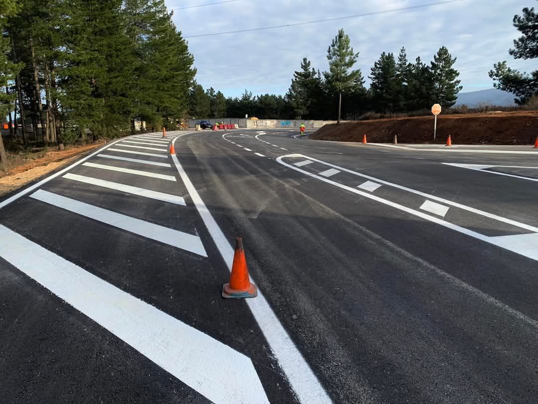 Un cono de tráfico está sentado al costado de una carretera.