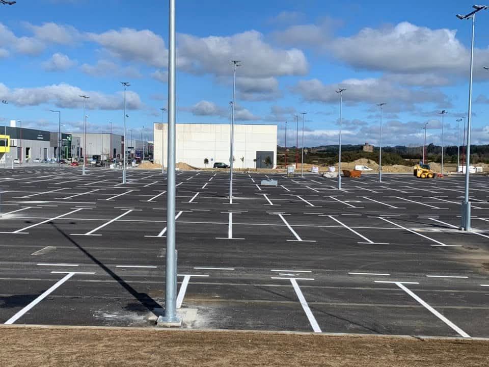 Un estacionamiento vacío con un edificio al fondo.