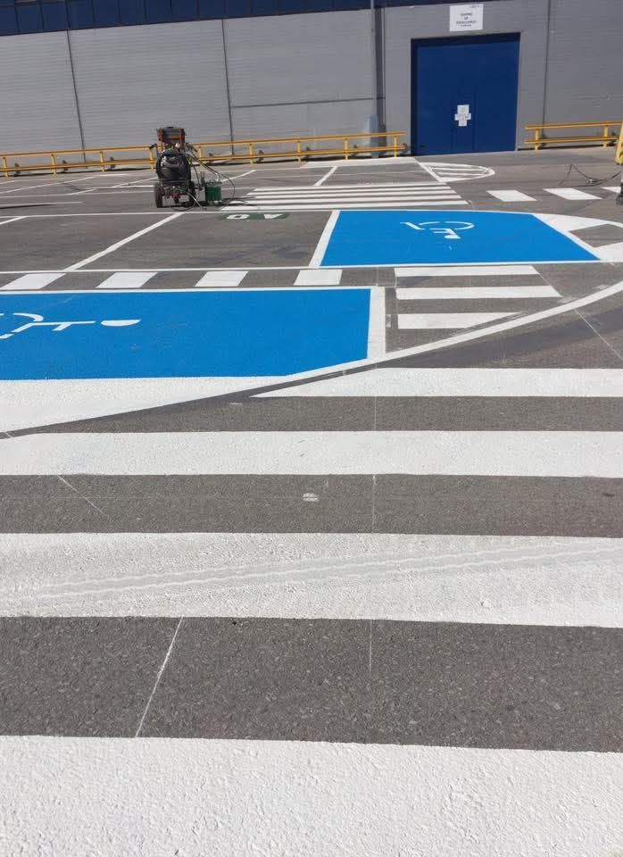 Se está pintando un lugar de estacionamiento para discapacitados en un estacionamiento.