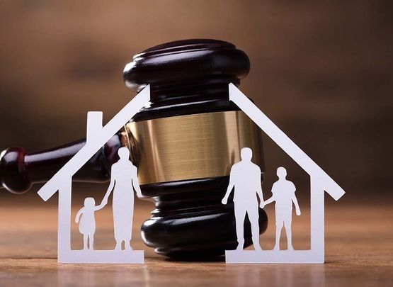 Silueta con forma de casa sobre un mazo, que simboliza el derecho de familia o la ejecución hipotecaria de una vivienda.