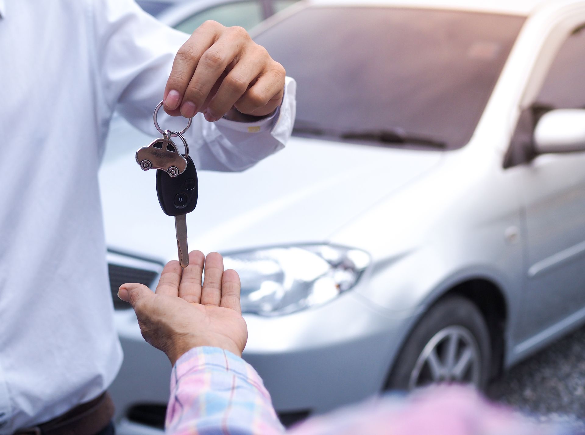 Homme qui donne la clé d'une voiture à un autre