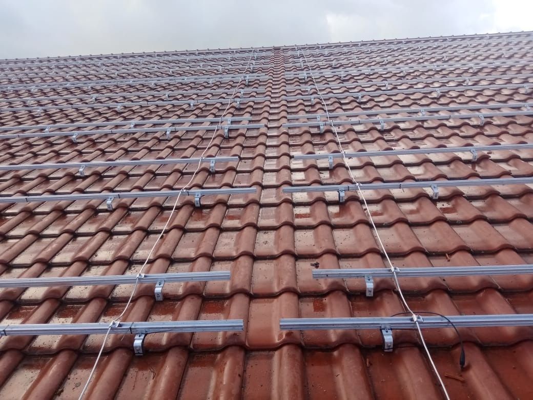 Braunes Ziegeldach mit installierten Montageschienen für Solarmodule.