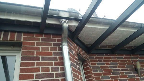 Fassade aus Backstein mit silbernem Fallrohr.