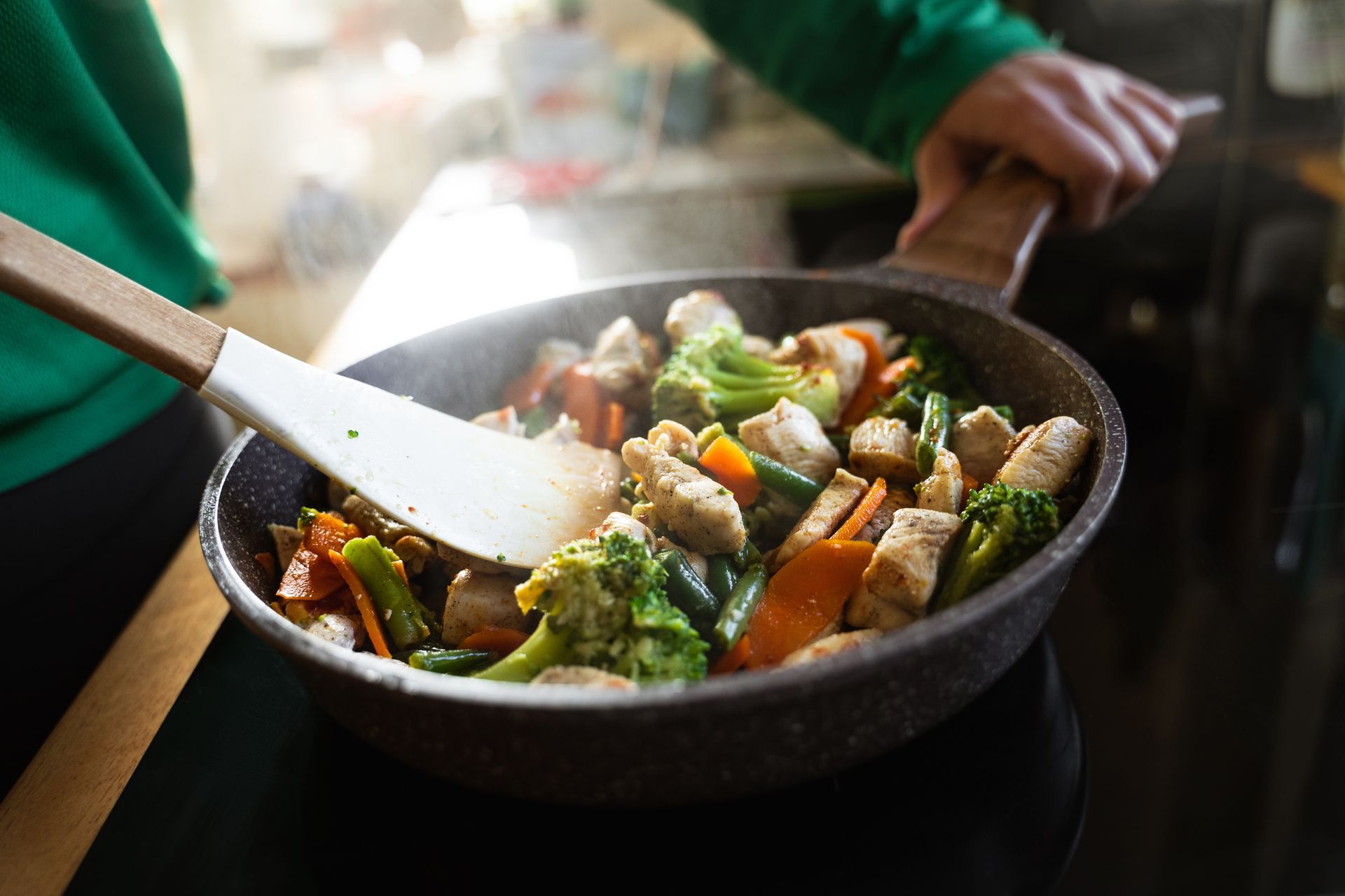 Personne en train de préparer un repas dans une poêle