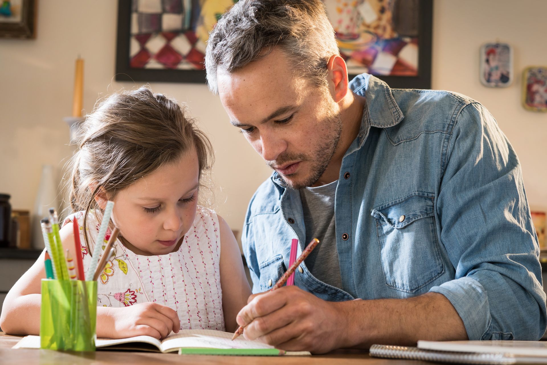 Homme aidant une enfant à faire ses devoirs
